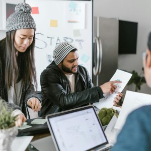 Team of young entrepreneurs brainstorming and discussing startup strategies in a modern office setting.